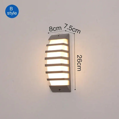Modern gray metal DecorBites LED outdoor wall sconce with horizontal slats emitting warm light for patio use