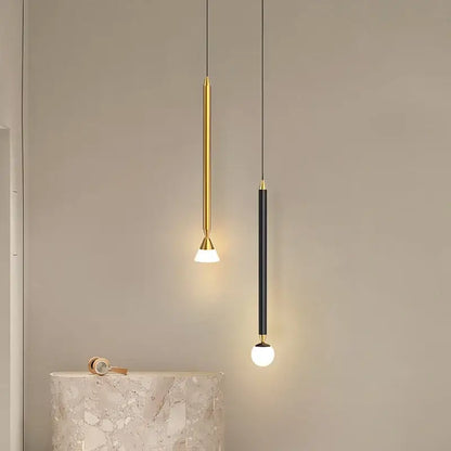 Two minimalist decorbites led pendant lights with gold and black finishes featuring sleek cylindrical bodies and warm globe bulbs