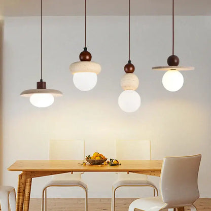 Four matte white concrete shade pendant lamps with dark brown accents hang above wood table decorbites led pendant