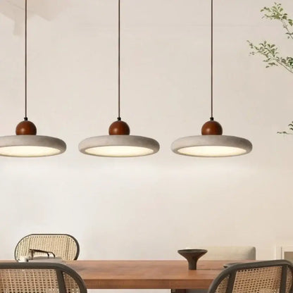 Decorbites led pendant lamp with three circular yellow stone concrete shades and warm wooden tops hanging from black cords