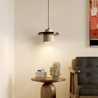 Modern concrete decorbites led pendant lamp with dark wood accent ring and textured cylindrical shade in yellow travertine