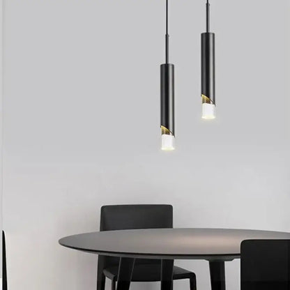 Two black DecorBites LED pendant lamps with gold-accented acrylic cutouts hang above a modern dining table