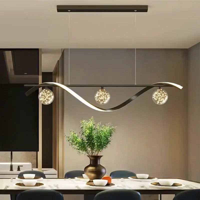Modern black metal decorbites led pendant with three glass globes emitting warm light for dining room and kitchen island