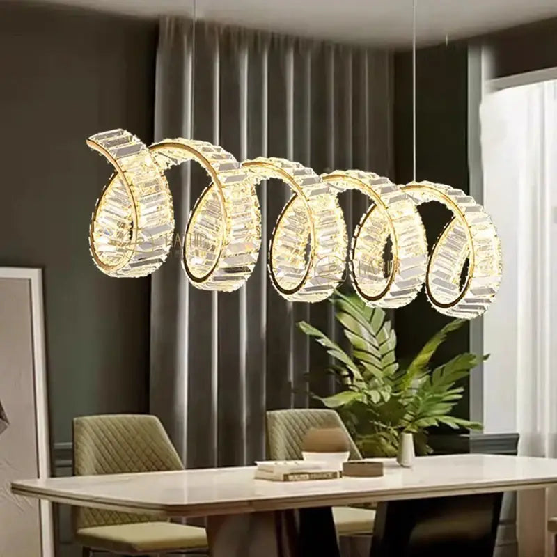 A modern gold-toned DecorBites led pendant light chandelier with five interlocking spiral rings for living room decor