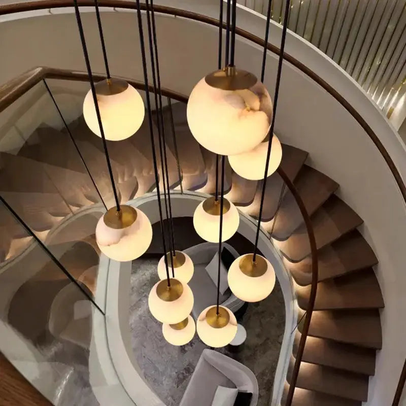 A modern decorbites led pendant light chandelier with spherical warm opaline glass shades and brass ceiling mount