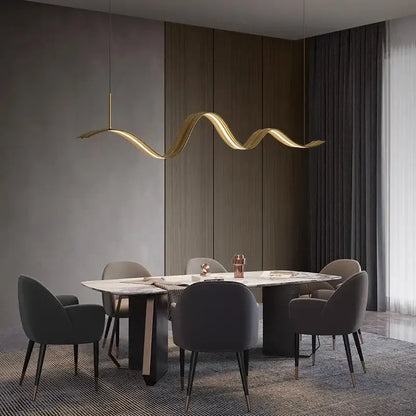Golden wave-shaped decorbites led pendant light with sleek metallic finish hanging above dining table for modern decor