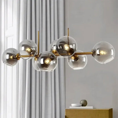 Modern gold-toned decorbites led pendant light chandelier with clear glass spheres and exposed bulbs for living room decor