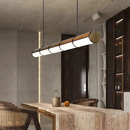 Modern cylindrical DecorBites LED pendant light with natural wood finish and metallic accents for living and dining rooms
