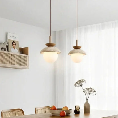 Two minimalist matte beige ceramic shades decorbites led pendant light with wooden accents above dining table