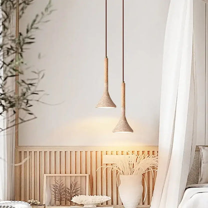 Two minimalist decorbites led pendant lights with yellow travertine ceramic shades and wooden stems hanging from dark cords