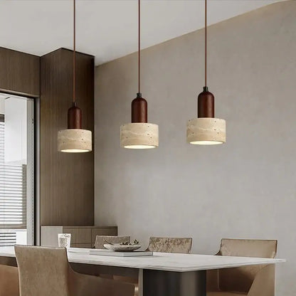 Three decorbites led pendant lights with dark brown metal tops and textured beige concrete shades above dining table