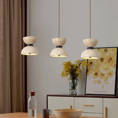 Three decorbites led pendant lights with yellow travertine stone finish and black metal accents for living room use