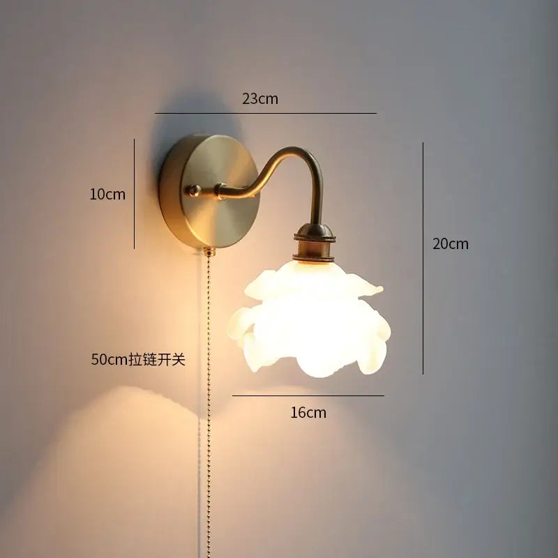 Antique brass finished decorbites led petal wall sconce with translucent white glass flower shade and 50cm pull chain switch