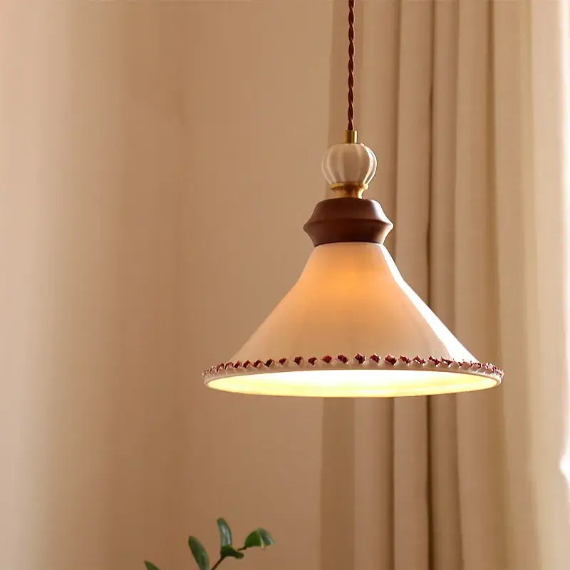 Cream-colored ceramic led rose flower pendant lamp with dark wood accent and decorative red bead trim by DecorBites™