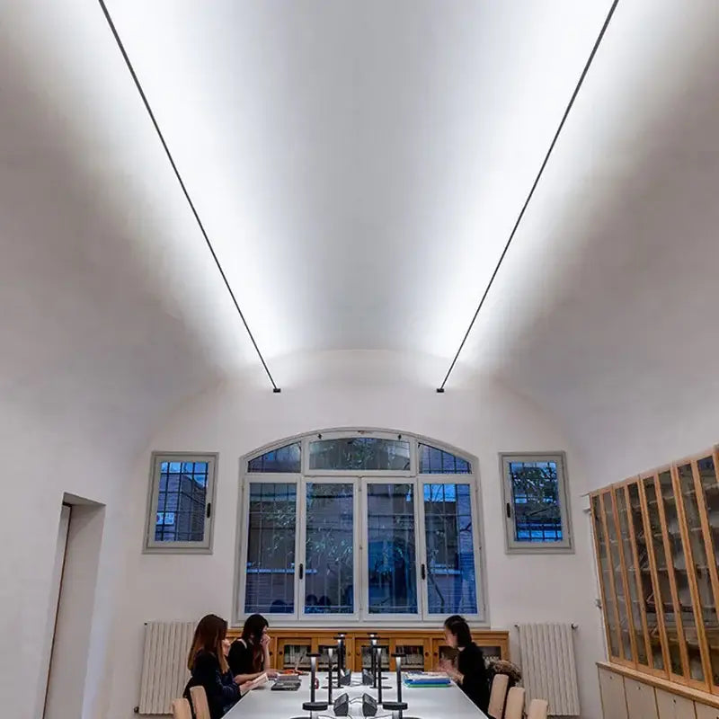 A modern conference room featuring decorbites led skyline steel pendant lights with minimalist linear design