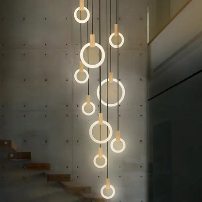 Modern minimalist DecorBites LED stair chandelier with glowing circular rings, black cords, and wooden accents for bedrooms
