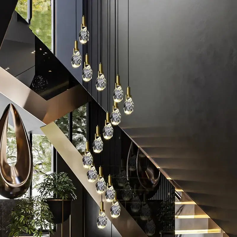 A modern decorbites led staircase pendant light with faceted crystal droplets and gold-toned metal fixtures