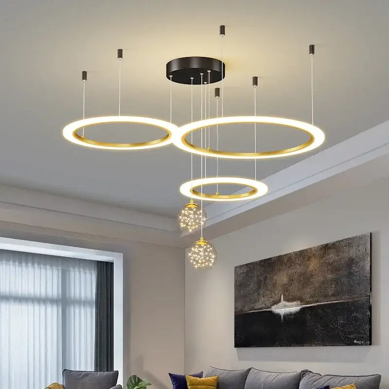 Modern gold-toned circular decorbites led star chandelier with black mount and crystal globe pendants for living room decor