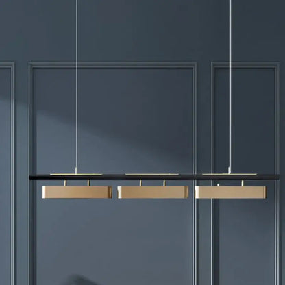 Modern minimalist strip pendant lights with three rectangular gold-toned fixtures for dining by DecorBites™