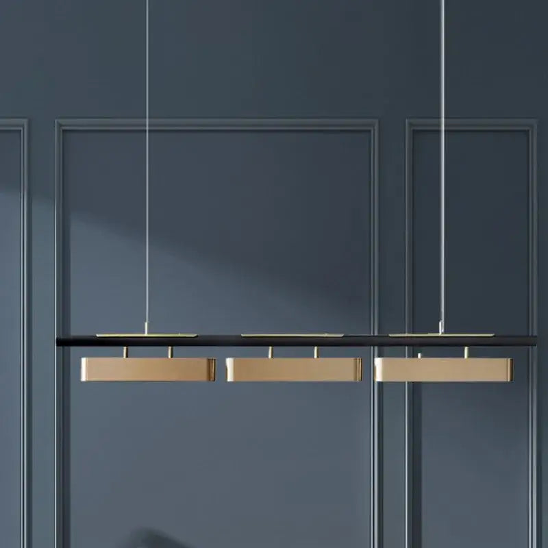 Modern minimalist strip pendant lights with three rectangular gold-toned fixtures for dining by DecorBites™