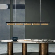 DecorBites™ modern minimalist strip pendant lights feature a sleek black bar with five gold-toned minimalist strip LED fixtures