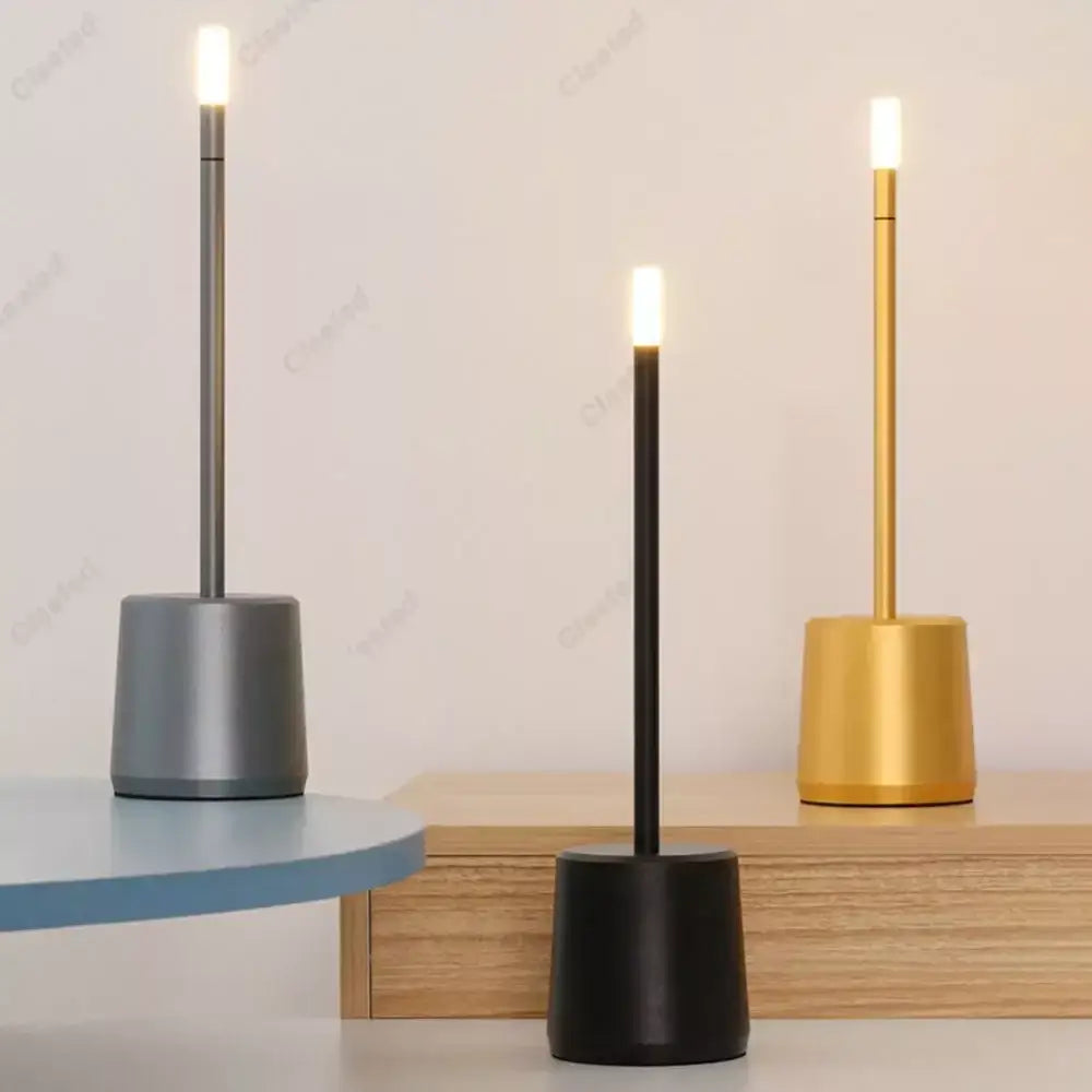 Three decorbites led touch table lamps with cylindrical bases in matte gray black and brushed gold finishes for home use