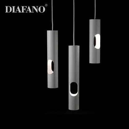 Three sleek matte gray cylindrical decorbites led tube surface mount pendant lights with oval cutouts emit soft glow