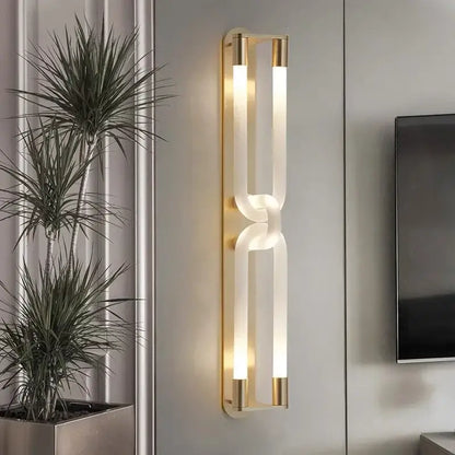 Modern gold-toned DecorBites LED tube wall sconce with two illuminated acrylic tubes in sleek interlocking design