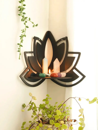 Black metal lotus floating wall shelf holding candles and colorful stones for stylish home decor by DecorBites™