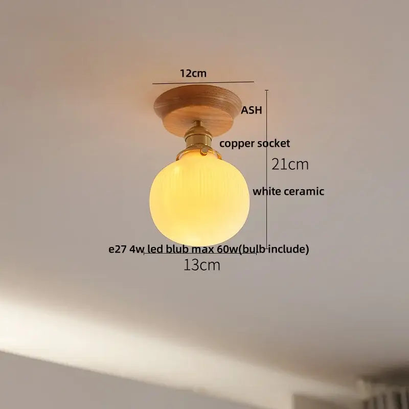 A warm glowing white ceramic ceiling light with brass copper socket and ash wood mount decorbites lotus glass led