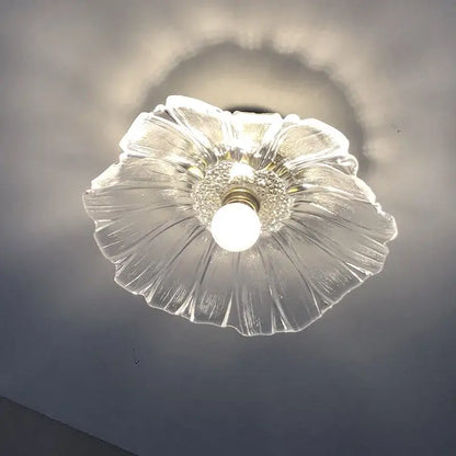 Clear glass ceiling light fixture with a petal-like design and central bulb.