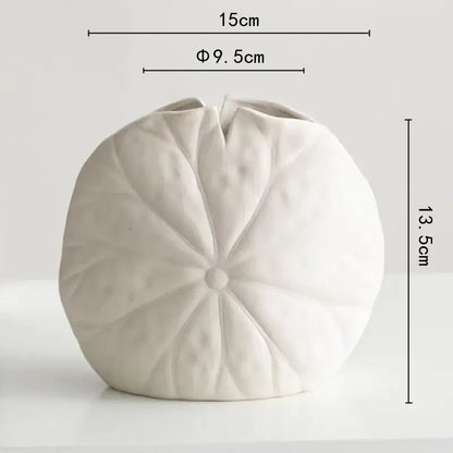 A white decorbites lotus leaf ceramic vase shaped like a lotus flower with detailed petal ridges and central indentation
