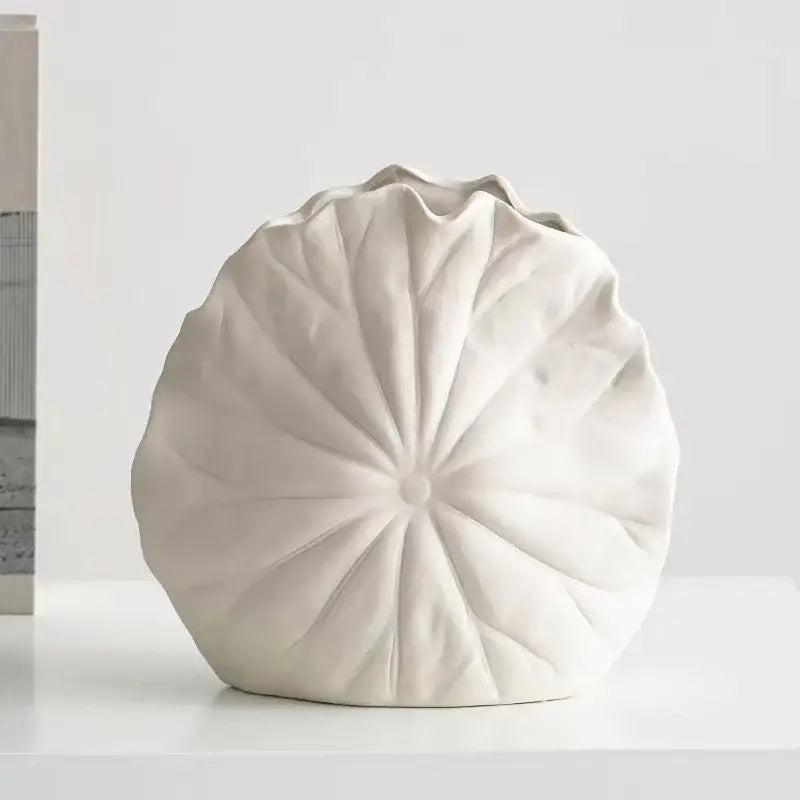 A matte white decorbites lotus leaf ceramic vase with radiating ridges and ruffled top for floral arrangement