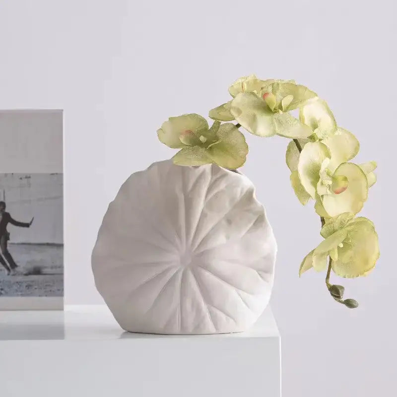 DecorBites lotus leaf white ceramic vase with lotus petal design holds pale green orchids for room decoration