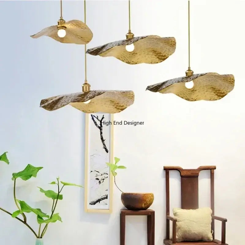 Three golden lotus leaf led pendant lights with hammered texture hanging from brass fixtures by decorbites lotus leaf