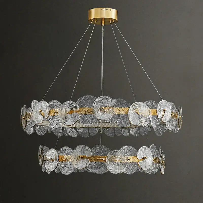 A decorbites lotus leaf two-tiered led chandelier with clear textured glass discs and brass finish for living room lighting