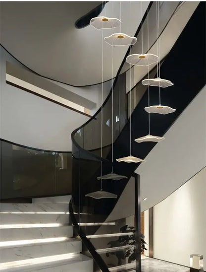 Modern white pendant lights with gold centers in a cascading decorbites lotus leaf led chandelier above staircase