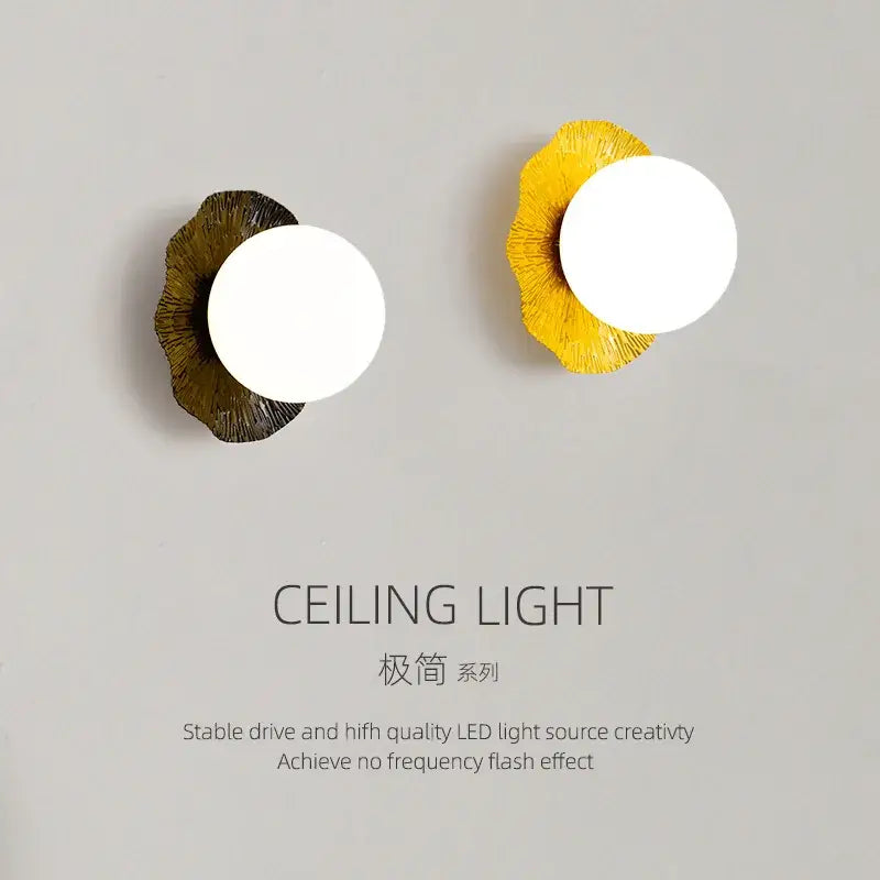 Two decorbites lotus leaf wall lamps with circular white led bulbs on matte gold and vibrant yellow leaf-shaped bases