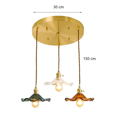 Gold-toned decorbites lotus leaf pendant lights with three green and amber glass shades suspended by twisted bronze cords
