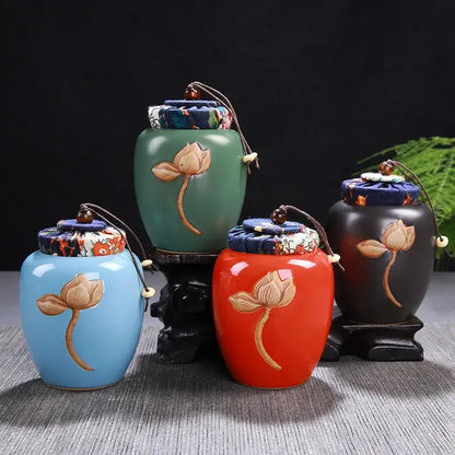 Four ceramic tea pot storage jars with lotus pattern designs in blue green red and black with fabric lids by DecorBites
