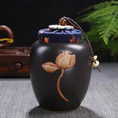 Black ceramic tea pot storage jar with lotus pattern and navy blue fabric lid with orange embroidery by decorbites