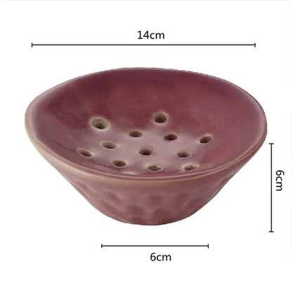 A rustic matte lotus root clay bowl with deep reddish brown glaze and circular drainage holes for home decor use