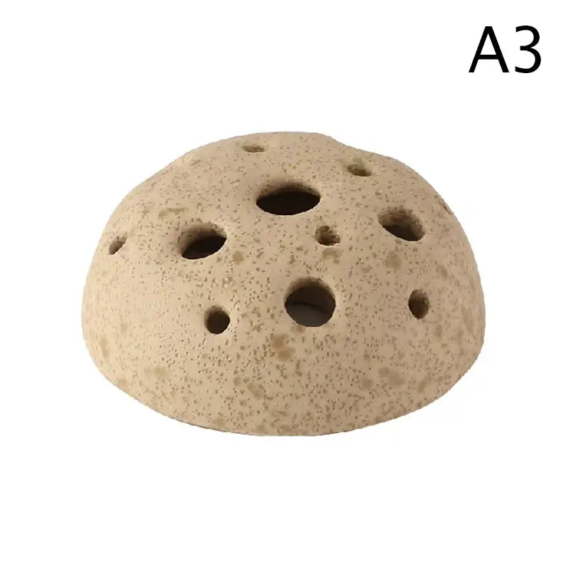 Beige porous lotus seedpod ceramic vase with circular holes and rounded dome shape in stone sand finish from decorbites