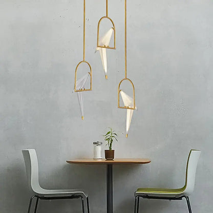 Three gold-toned decorbites love bird chandelier pendant lights with white paper crane shades for dining room