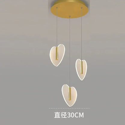 Modern gold-toned pendant light fixture with three glowing heart-shaped shades from decorbites love chandelier