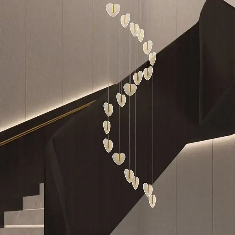 A modern DecorBites love chandelier with white heart-shaped lights and gold crystal accents for staircase and living room