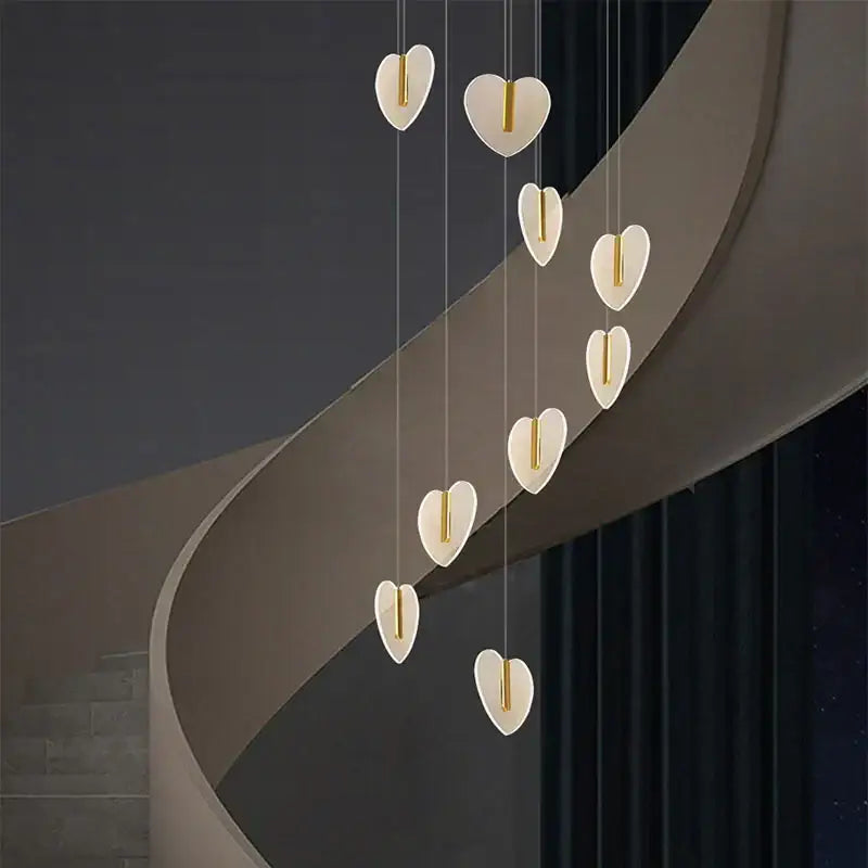 A modern decorbites love chandelier with matte white heart-shaped pendants and gold accents for staircase lighting