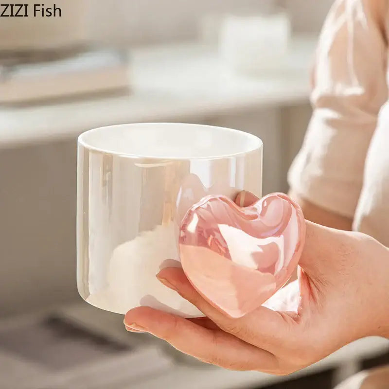 A translucent pink love heart ceramic trinket with glossy finish held in hand for decorBites™ ceramic mug collection