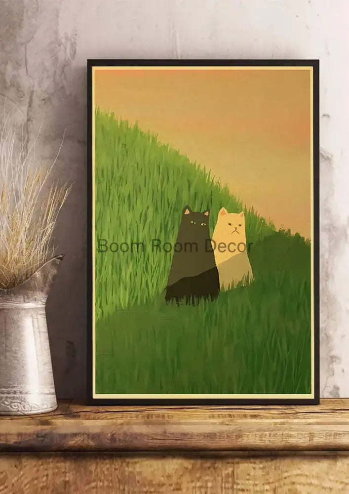Black-framed DecorBites™ lover cat paper poster with black and cream stylized cats in green grass under orange sky