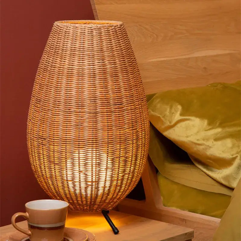 A warm-toned lucide colin rattan floor lamp with tapered shade and black metal base by decorbites lucide colin